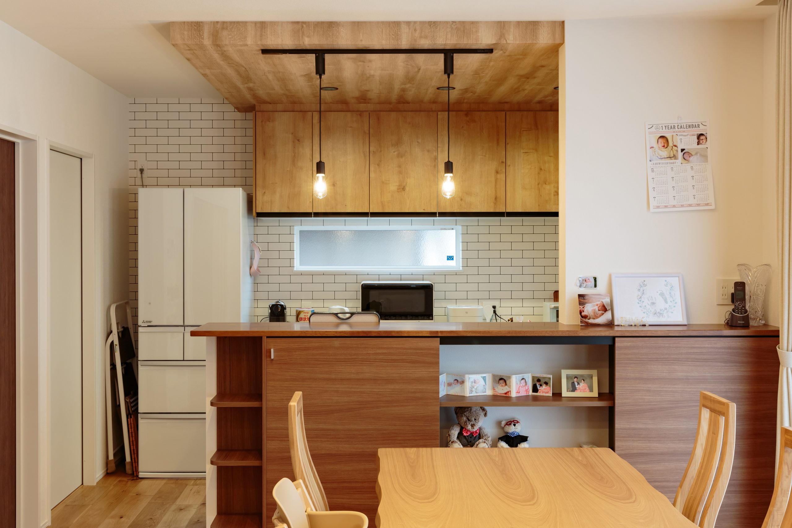 下がり天井とタイル調クロスが映えるキッチン。見せる×隠すのバランスが絶妙なカウンター収納も素敵
