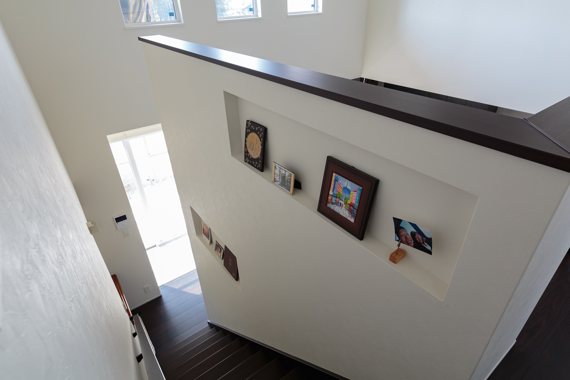 吹き抜けのリビング階段は、高さのある腰壁に大きなニッチをつくり、お洒落なギャラリースペースにアレンジ。写真や絵を立てかけて飾れるので壁を傷つけなくて済み、レイアウト変更も簡単に行えます。