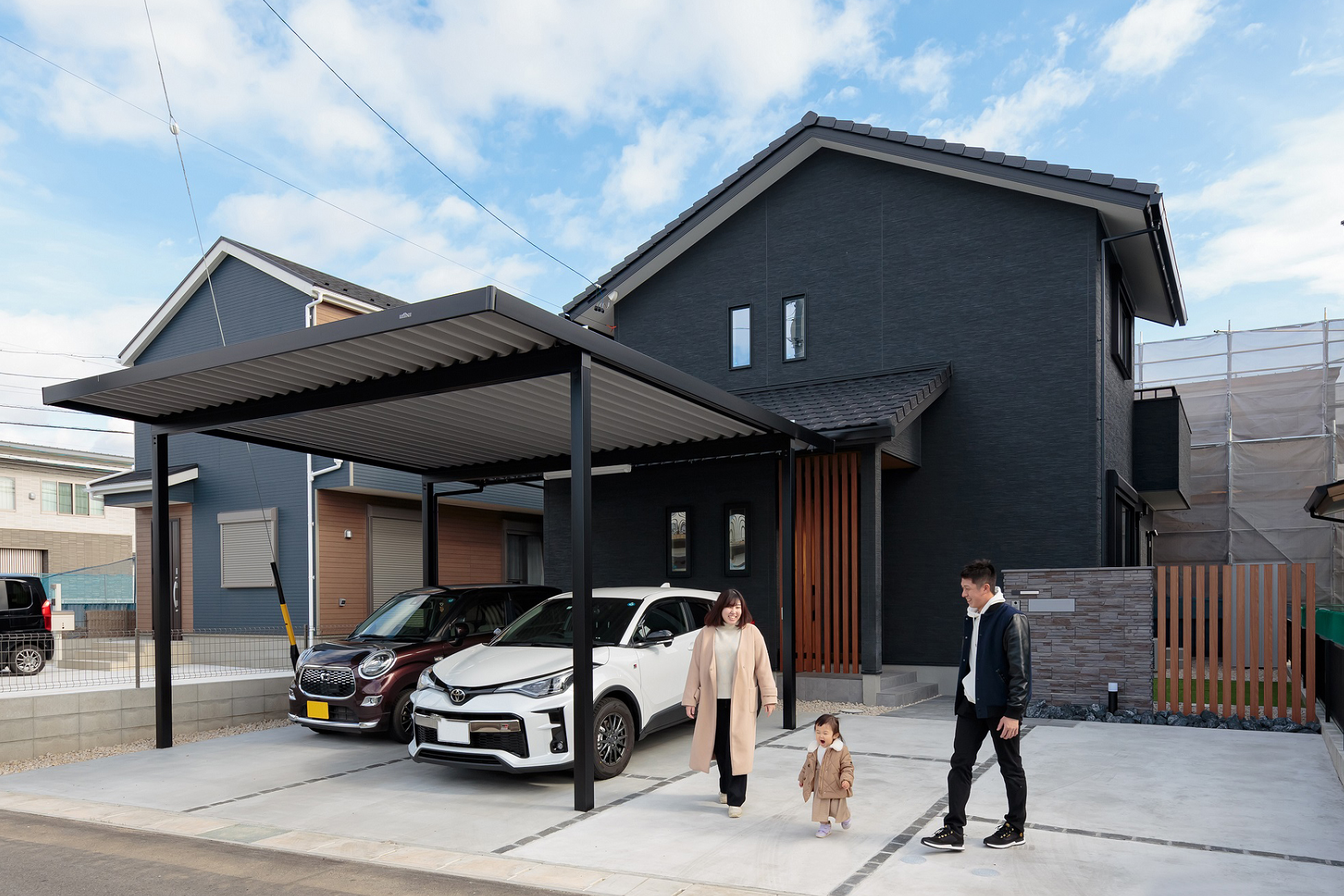 瓦の切妻屋根で和モダンにコーディネートした外観。トラックを駐車することもあるため高さのあるカーポートを採用