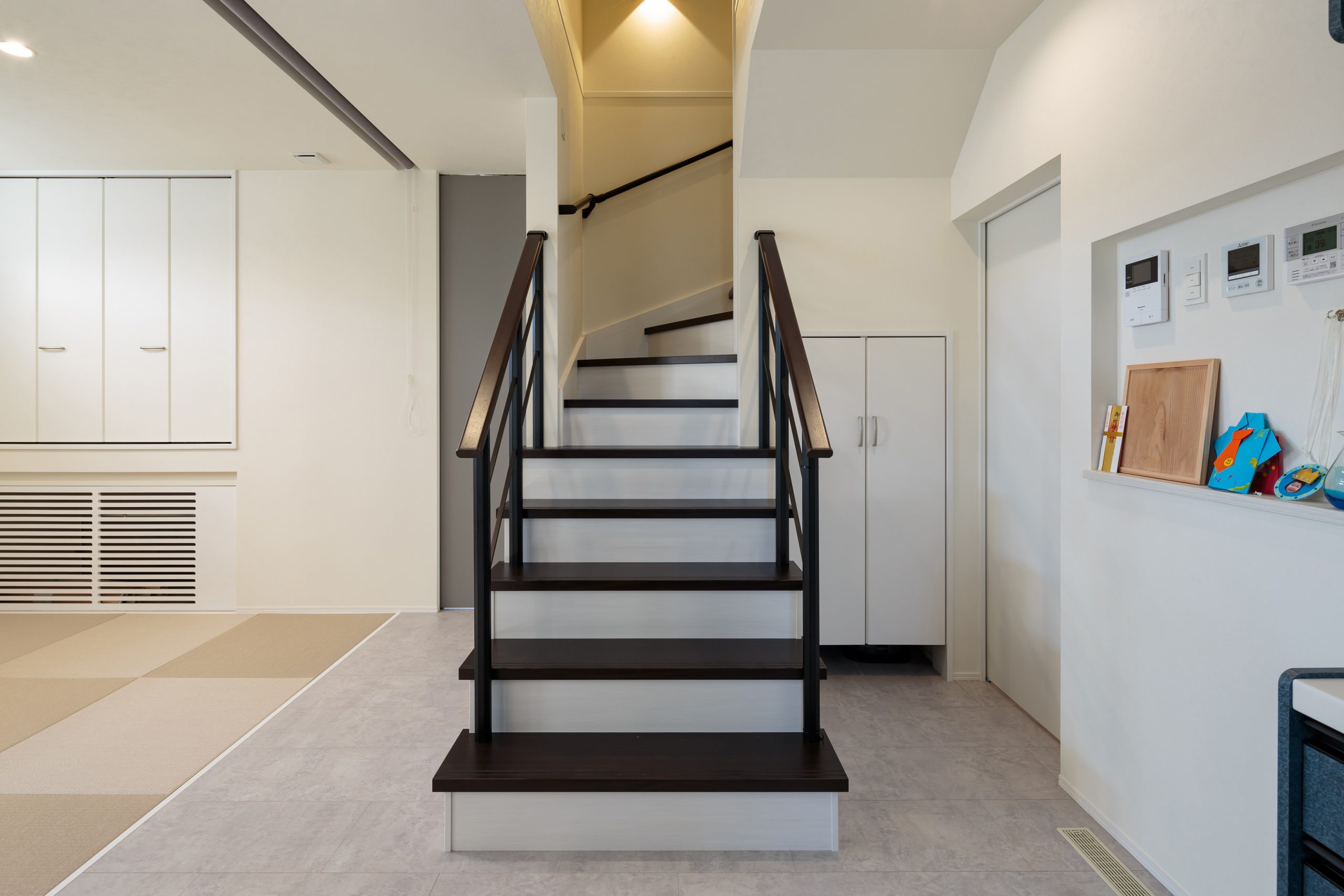 リビング階段を見せるデザインにして空間を緩やかにゾーニング。階段下は収納にしてデッドスペースを有効活用