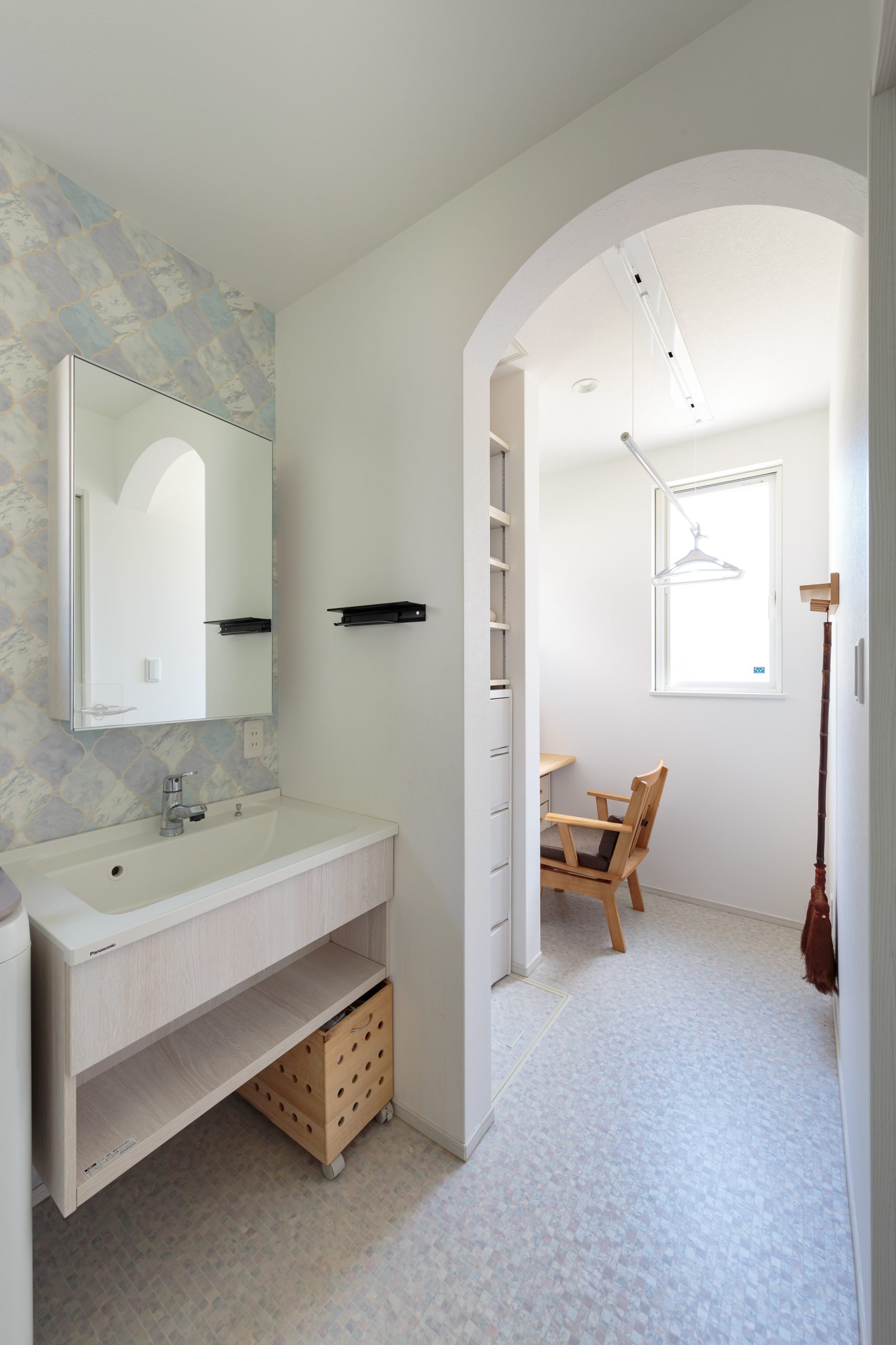 洗面脱衣室と家事コーナーを横並びにした機能的な間取り。アーチ型の垂れ壁でシンプルでちょっと可愛い空間をデザインしました。洗面台は標準仕様の中から造作に見える物を選んでいます。